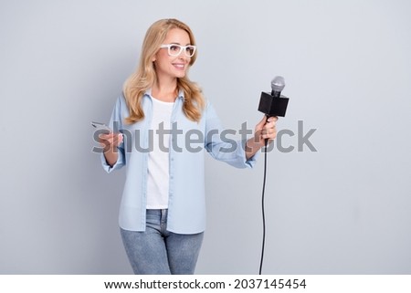 Photo of correspondent newsmaker hold mic phone take interview wear specs blue shirt isolated grey color background