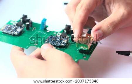 Caucasian man developing the prototype of an IoT robot. PCB. PCBA.