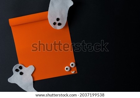 Mackeup Halloween. An empty orange leaf on a black background and white ghosts. Happy Halloween, space for text