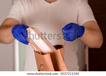 A closeup shot of a delivery man holding the delivery packages