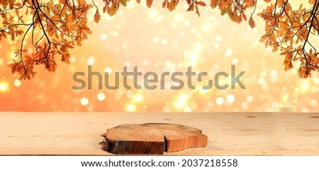 Autumn abstract composition with oak leaves on blurred bokeh background and empty wooden table for product presentation, thanksgiving day concept, banner or splash, postcard,