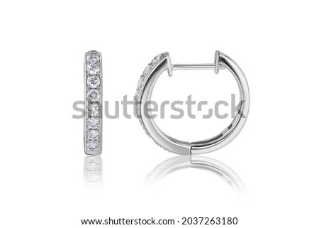 Subject Shot of Diamond Huggie Hoop Earrings on a White Background with Reflection. Earrings metal is 14k White Gold.  Royalty-Free Stock Photo #2037263180