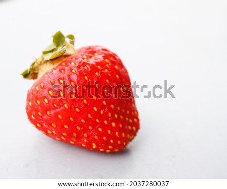 A closeup shot of a bright red delicious strawberry on a white background