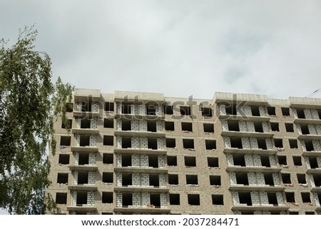 Building under construction in the city. Construction of a multi-storey building. Construction works on the street. Apartment unfinished building in Russia.