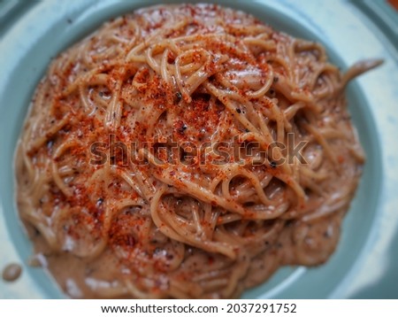 Defocused abstract background of spaghetti carbonara with a sprinkling of chili powder