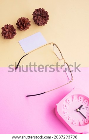metal square glasses in the photo in minimal summer style on a pastel pink and yellow background. Alarm Clock , Pine Tree Flowers , Business Cards
