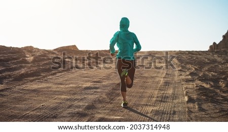Fitness woman trail runner cross country running  on desert Royalty-Free Stock Photo #2037314948