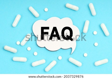 Medicine concept. On a blue background pills and a plate. Inside the sign it says - FAQ
