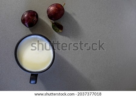 cup of hot milk with plums on a gray background, horizontal, mockup, Flat Lay