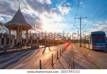 Popular destination of Konya city centre with Monument to the martyrs of the Independence War - Blue tram on the street at sunset - Konya, Turkey Royalty-Free Stock Photo #2037391115