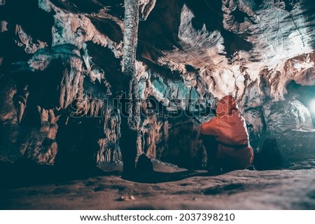 Cave stalactites and formations and a caver in Vadul Crisului cave, Romania Royalty-Free Stock Photo #2037398210