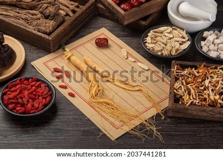 Ginseng and traditional Chinese medicine on the table.English Translation:Traditional Chinese medicine is used in the prevention and treatment of diseases, has the function of rehabilitation. Royalty-Free Stock Photo #2037441281