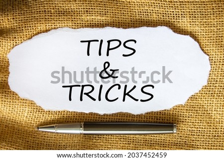 Tips and tricks symbol. Words 'Tips and tricks' on white paper. Black metallic pen. Beautiful canvas background. Business, tips and tricks concept. Copy space.