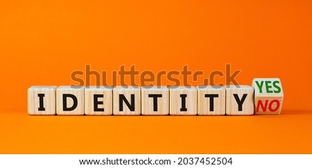 Identity symbol. Turned a wooden cube and changed words 'identity no' to 'identity yes'. Beautiful orange background. Business and identity concept, copy space.