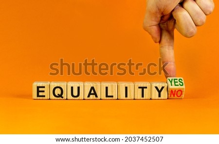 Equality symbol. Businessman turns a wooden cube and change words 'equality no' to 'equality yes'. Beautiful orange background. Business and equality concept, copy space.