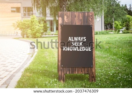 Always Seek Knowledge. Wooden advertising banner on the street.