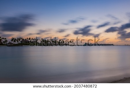 Palm trees on tropical coast at sunset. Crossroads Maldives, hard rock hotel, june 2021. Long exposure picture
