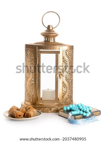 Muslim lantern with Quran, tasbih and Turkish sweets on white background Royalty-Free Stock Photo #2037480905