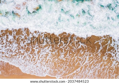 Concept summer sunny travel. Turquoise water with wave with sand beach background from aerial top view.