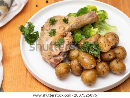 Chicken and baby potatoes baked with rosemary. On a wooden table, selective focus. top view