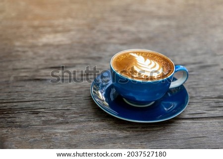 happy new year 2022 with late art on blue coffee cup on wooden table. new year concept