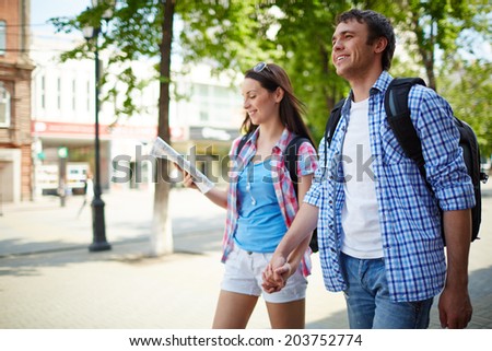 Couple of young travelers taking walk during journey Royalty-Free Stock Photo #203752774