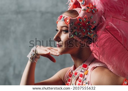 Woman in samba or lambada costume with pink feathers plumage. Royalty-Free Stock Photo #2037555632