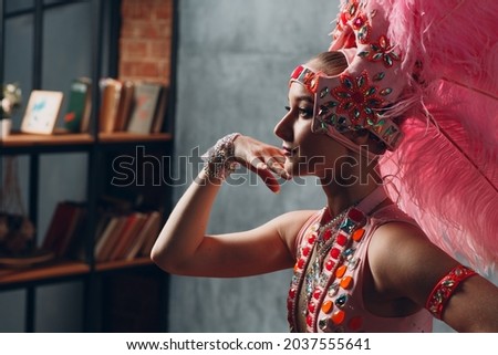 Woman in samba or lambada costume with pink feathers plumage. Royalty-Free Stock Photo #2037555641
