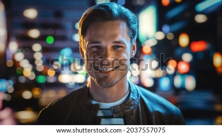 Portrait of Handsome Blonde Man Smiling, Looking at Camera, Standing in Night City with Bokeh Neon Street Lights in Background. Happy Confident Young Man with Stylish Hair. Close-up Portrait Royalty-Free Stock Photo #2037557075