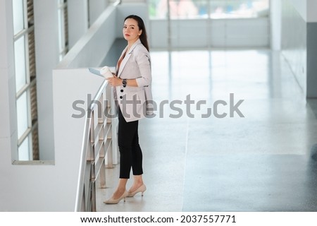 Portrait Of A middle-aged Asian woman Successful Business Woman Holding White take away coffee Of Hot Drink In Hand at office