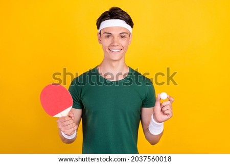 Photo of young charming cheerful man hold hands ball tennis player racket smile isolated on yellow color background