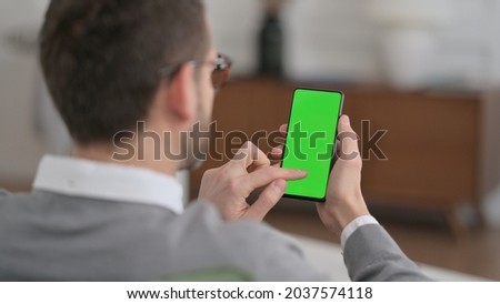 Man Using Smartphone with Chroma Key Screen at Home