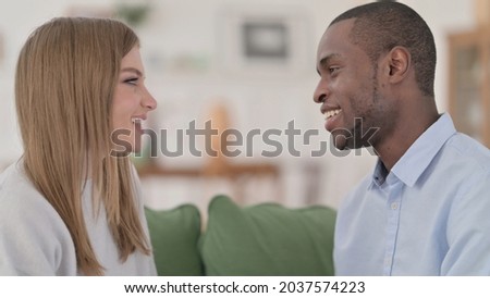 Happy Interracial Couple Smiling at Each other Lovingly at Home