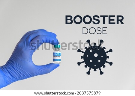 Hand in gloves holding vaccine for covid-19  Booster dose text and corona virus icon  Royalty-Free Stock Photo #2037575879