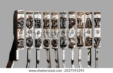 vintage old typewriter hammers  with the word  screenplay