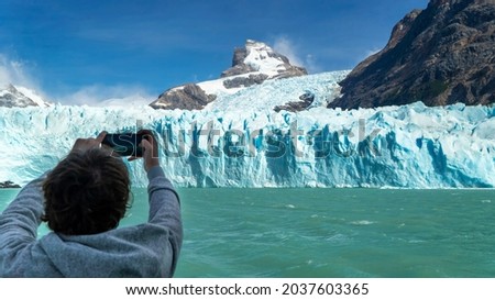 Person from a boat taking a picture of the Perito Moreno glacier.