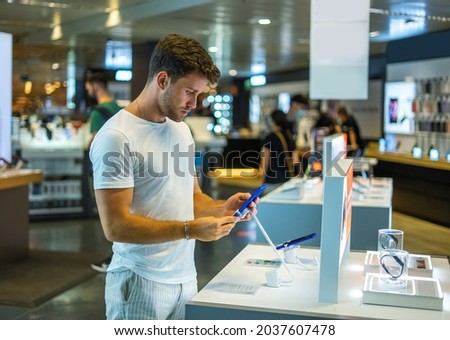 Customer checking phone in electronics store