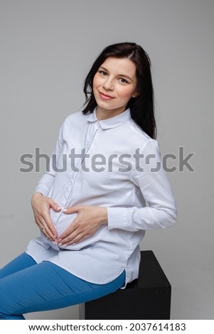happy young beautiful pregnant mum loves her little baby, picture isolated on grey background