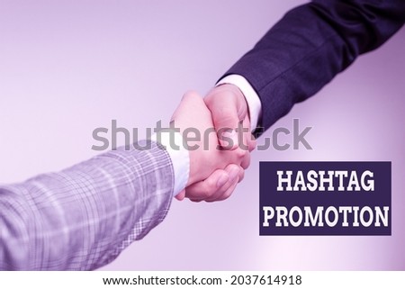 Text caption presenting Hashtag Promotion. Conceptual photo more showing can discover and engage with your content Two Professional Well-Dressed Corporate Businessmen Handshake Indoors