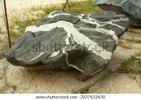 Beautiful stone in the park. A large piece of rock on the street. The cobblestones are prepared for installation in the garden. Sale of stones. Unusual stone.