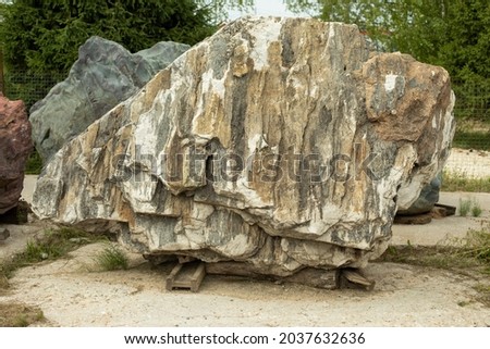 Beautiful stone in the park. A large piece of rock on the street. The cobblestones are prepared for installation in the garden. Sale of stones. Unusual stone.