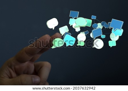 A person's hand reaching to 3D rendered speech bubble icons