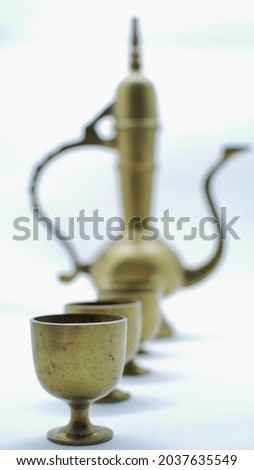 Golden yellow vintage teapot and glass on white background