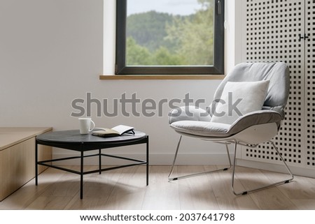 Modern style of living room, home interior. House design with furniture, minimalistic apartment. Comfortable chair near window, armchair decoration. Contemporary indoor with table. Royalty-Free Stock Photo #2037641798