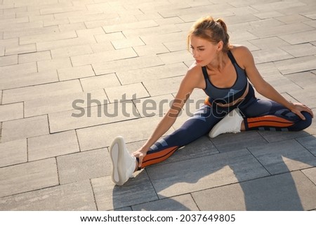 Beautiful woman in sportswear doing exercises outdoors on sunny day