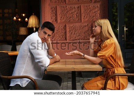 Man having boring date with talkative woman in outdoor cafe Royalty-Free Stock Photo #2037657941
