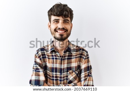 Hispanic man with beard standing over isolated background happy face smiling with crossed arms looking at the camera. positive person. 