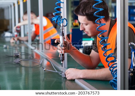 Men during precision work on production line, horizontal Royalty-Free Stock Photo #203767573