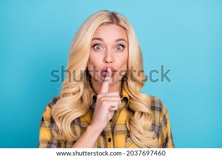 Portrait of attractive funny girlish mysterious wavy-haired woman showing shh sign isolated over bright blue color background
