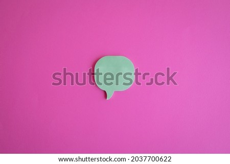 A cutout of a message icon on a pink background